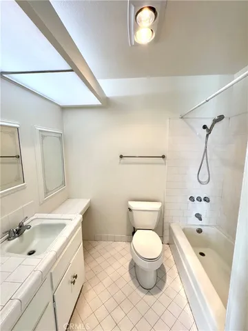 a bathroom with a granite countertop sink a toilet and a bathtub