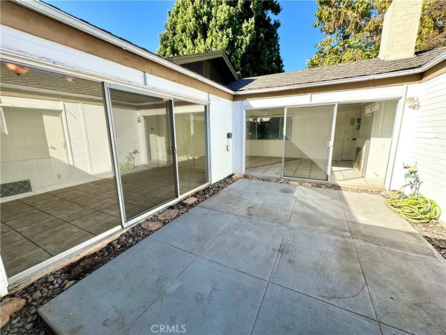 a view of a patio with table and chairs and wooden fence