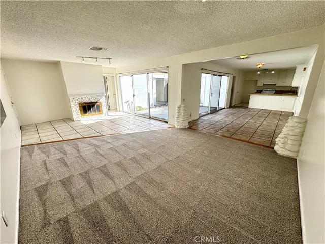 a view of an empty room with a fireplace and a window