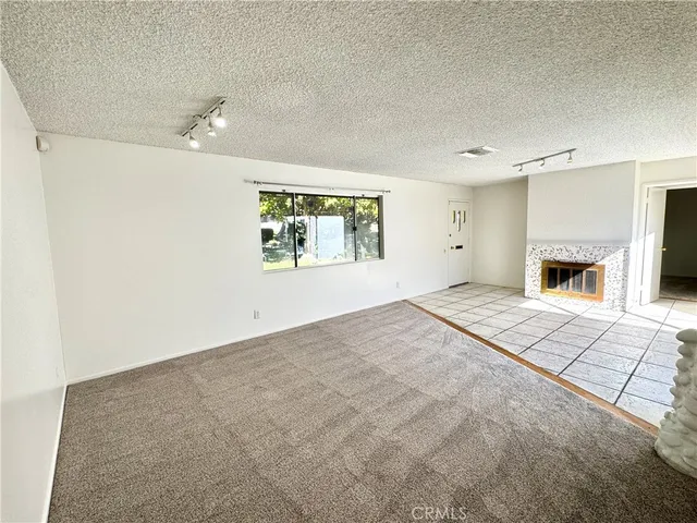an empty room with windows and fireplace