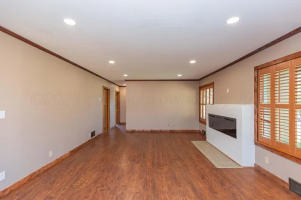 a view of empty room with wooden floor