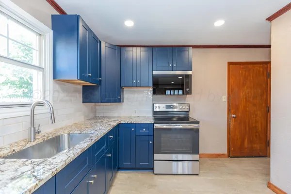 a kitchen with granite countertop wooden cabinets and stainless steel appliances