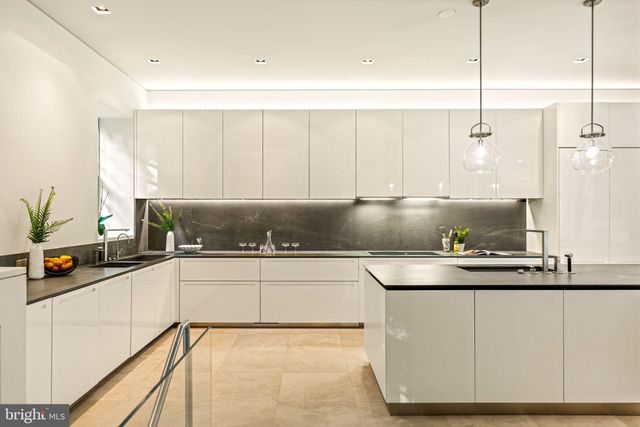 a kitchen with kitchen island granite countertop a sink a counter top space and cabinets