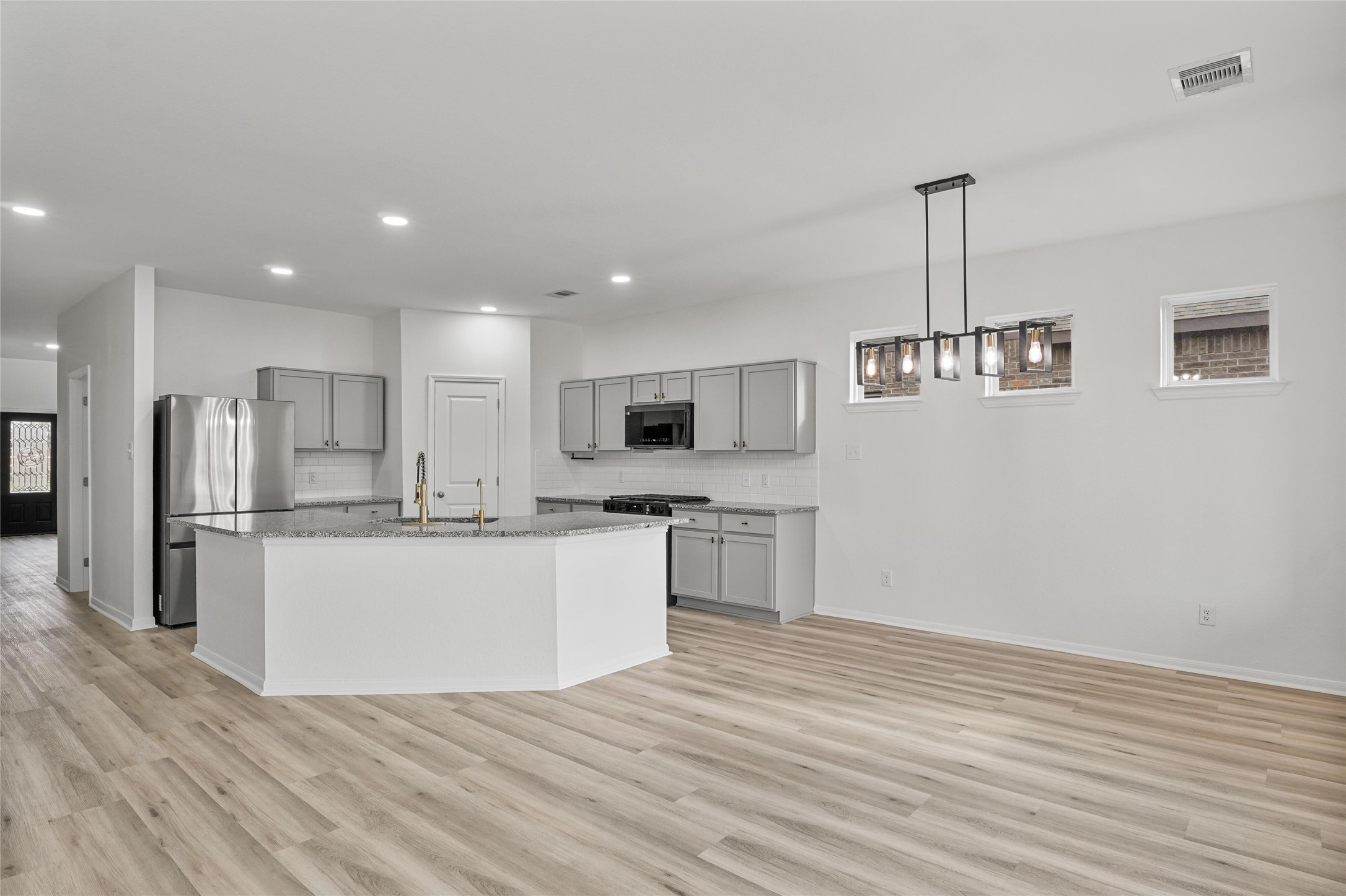 10511 Kings River Drive Rosharon, TX 77583 - Photo 6 of 25 a kitchen with stainless steel appliances kitchen island granite countertop a refrigerator a sink dishwasher a stove and white cabinets with wooden floor