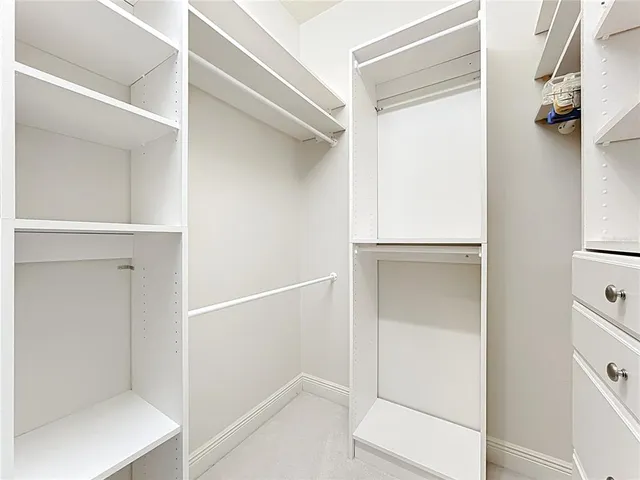 an empty room with windows and chandelier fan