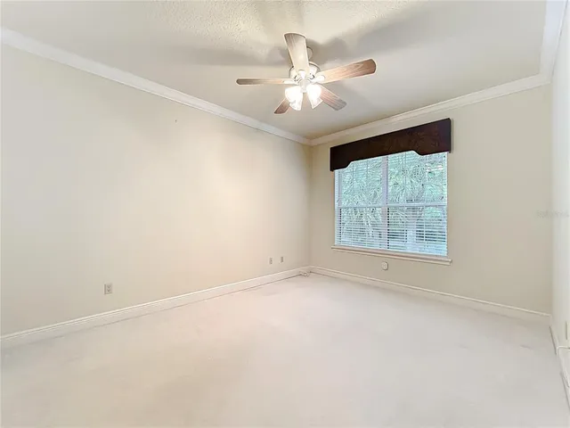 an empty room with a ceiling fan and a window