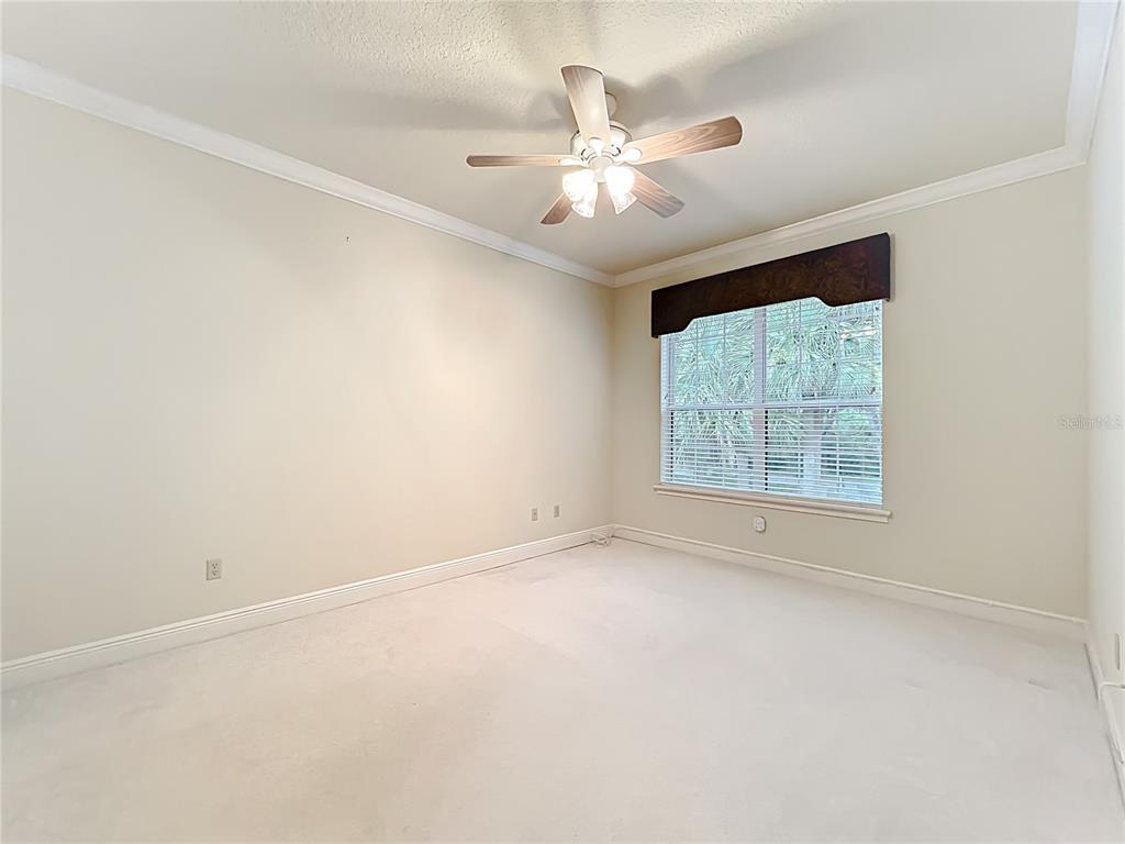 503 Camino Real, Unit 503 Howey-in-the-Hills, FL 34737 - Photo 32 of 65 an empty room with windows and chandelier fan