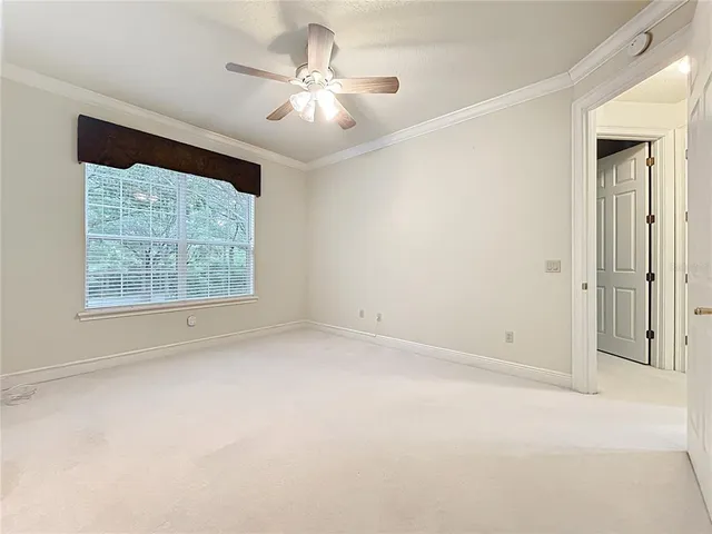 an empty room with a ceiling fan and a window