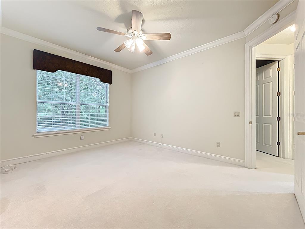 503 Camino Real, Unit 503 Howey-in-the-Hills, FL 34737 - Photo 33 of 65 an empty room with a chandelier fan and windows
