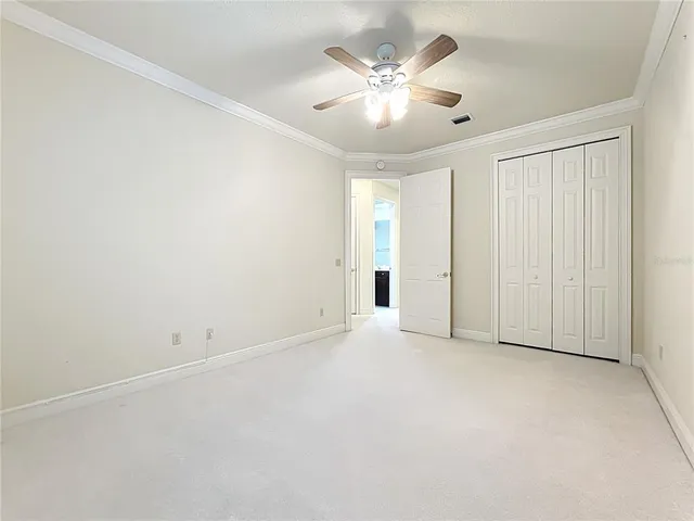 an empty room with a window and ceiling fan