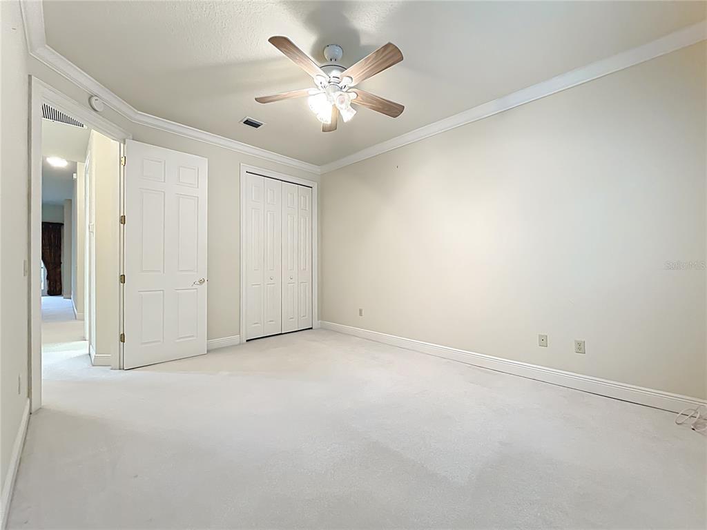 503 Camino Real, Unit 503 Howey-in-the-Hills, FL 34737 - Photo 35 of 65 an empty room with chandelier fan and closet area