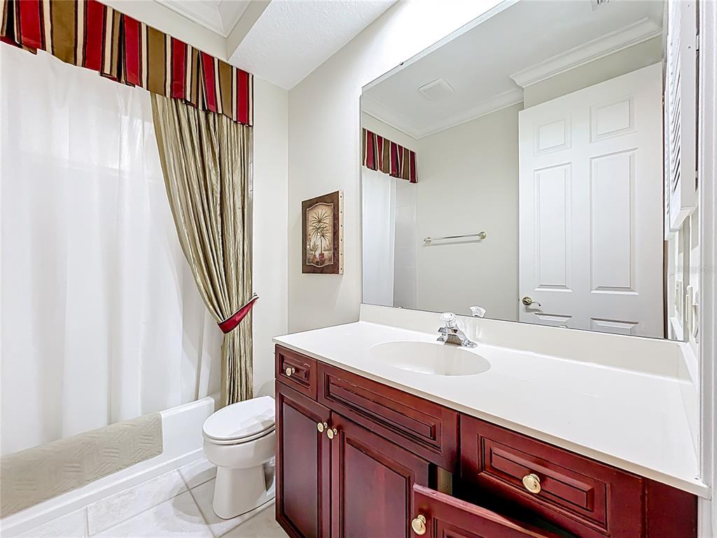 503 Camino Real, Unit 503 Howey-in-the-Hills, FL 34737 - Photo 41 of 65 a bathroom with a sink a toilet and shower curtain