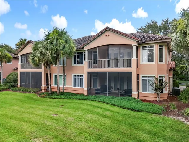 a front view of a building with a garden and parking