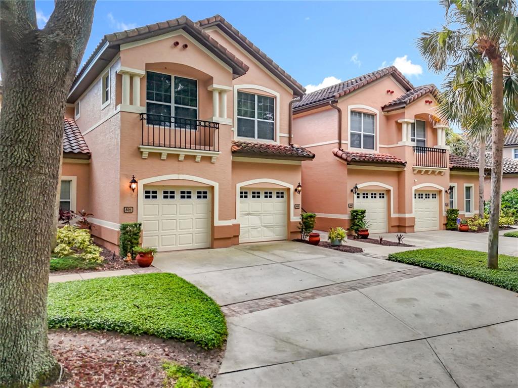 503 Camino Real, Unit 503 Howey-in-the-Hills, FL 34737 - Photo 63 of 65 a front view of a building with a garden and parking