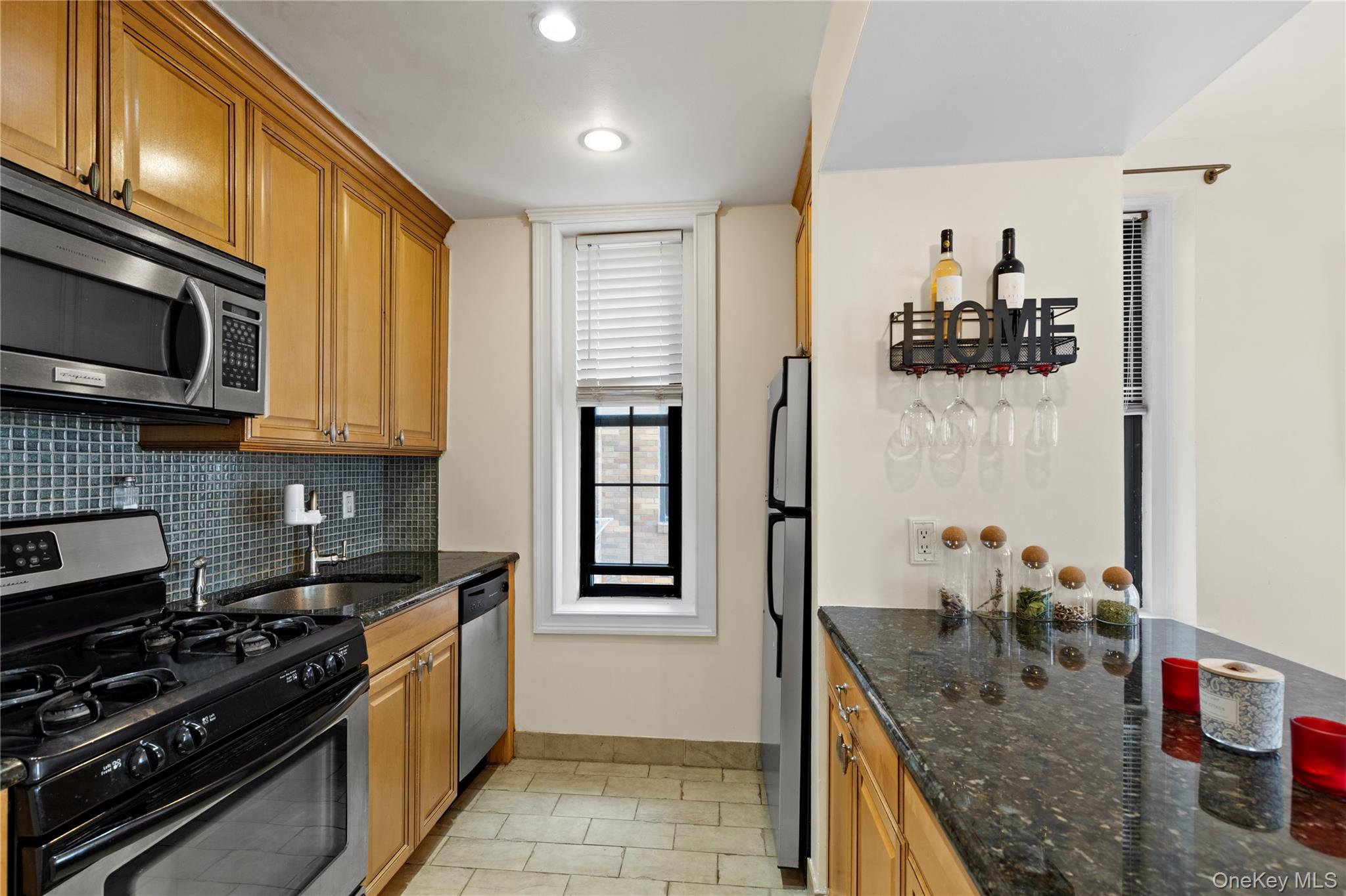 310 Riverside Boulevard, Unit 5F Long Beach, NY 11561 - Photo 5 of 23 Galley Kitchen with Open Island Seating Opposite Dining Area
