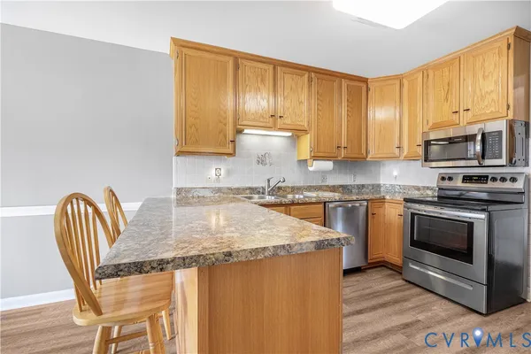a kitchen with granite countertop a stove a sink and a microwave