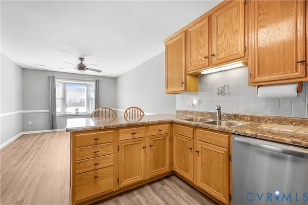 a kitchen with stainless steel appliances granite countertop a sink and cabinets with wooden floor