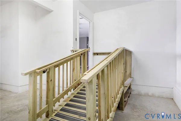 a view of staircase with railing and white walls
