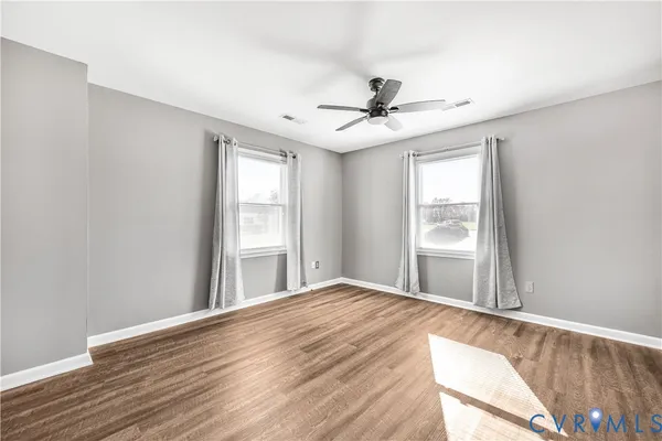 a view of a livingroom with a window and wooden floor