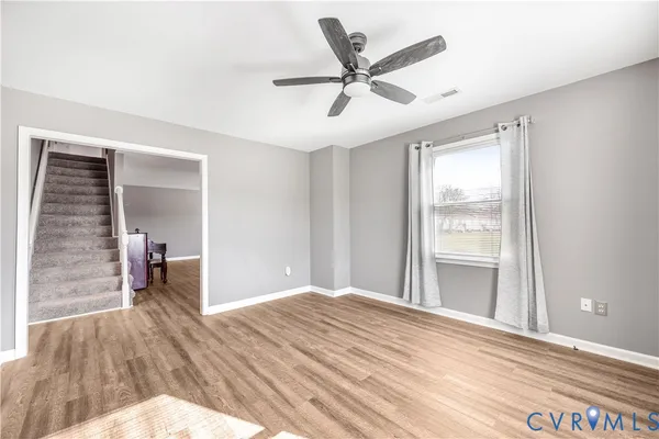 a view of a livingroom with wooden floor and a ceiling fan