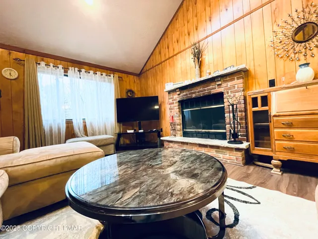 a living room with furniture a fireplace and a flat screen tv