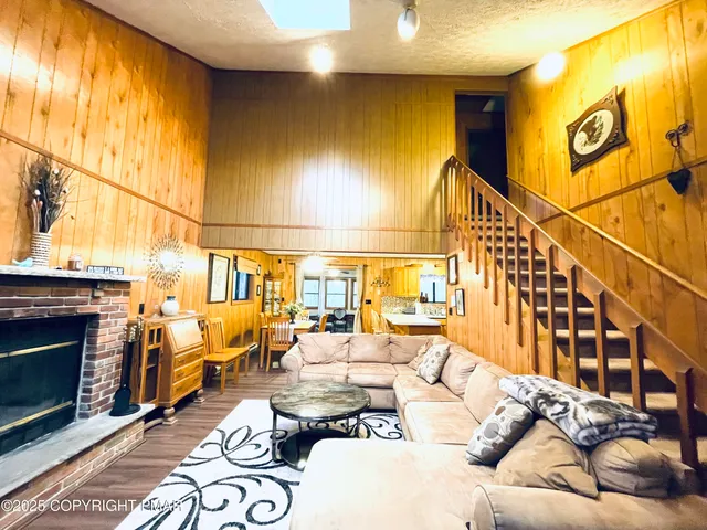 a living room with furniture a fireplace and a floor to ceiling window