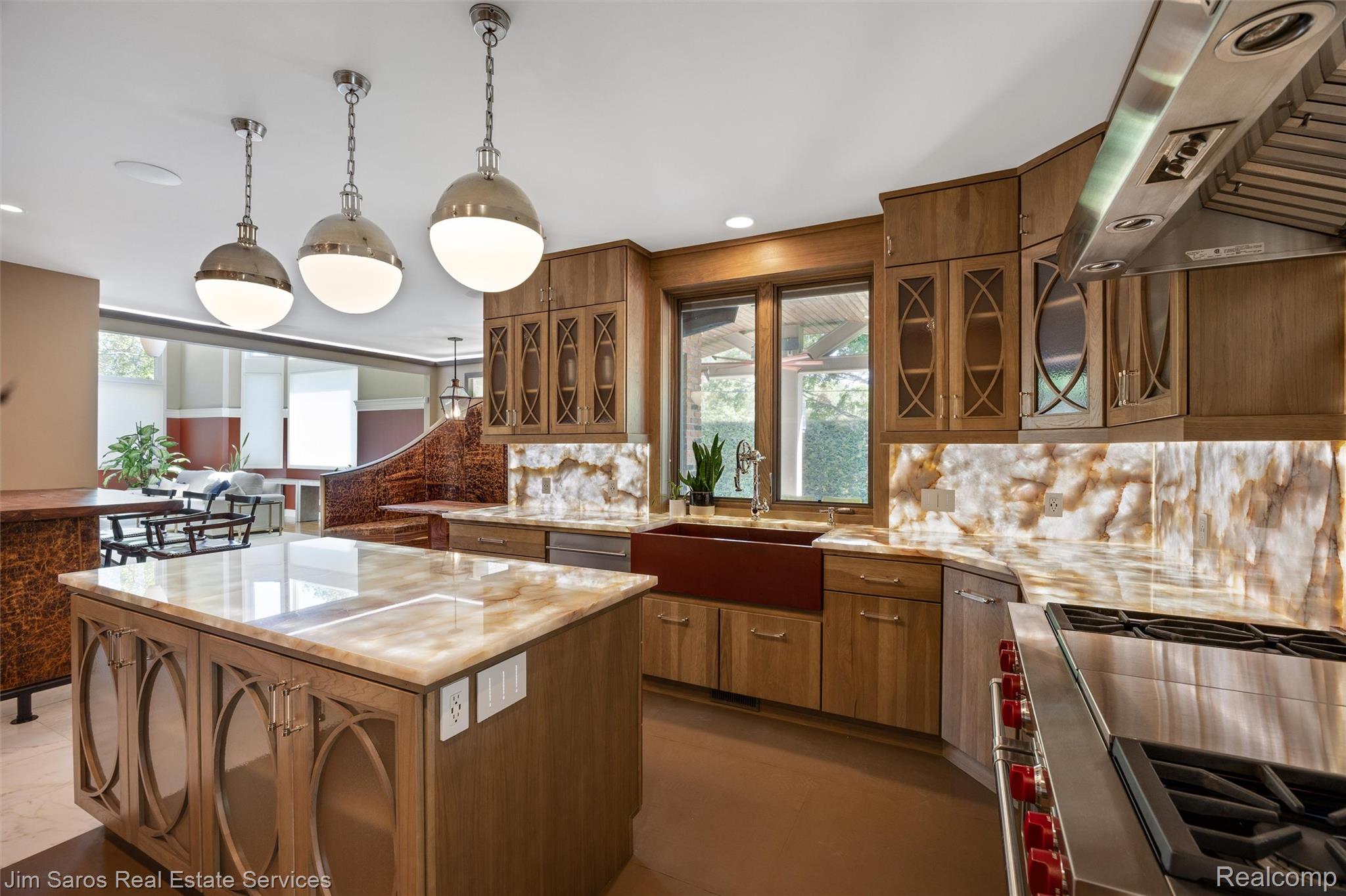 910 Edgemont Park Grosse Pointe, MI 48230 - Photo 8 of 56 Gourmet kitchen featuring custom wood cabinetry, a large center island with a stone countertop, an integrated farmhouse sink, a stainless steel range with a ventilation hood, and three pendant light fixtures