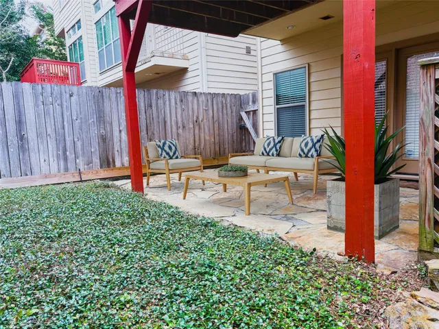 a garden with a bench in front of the house