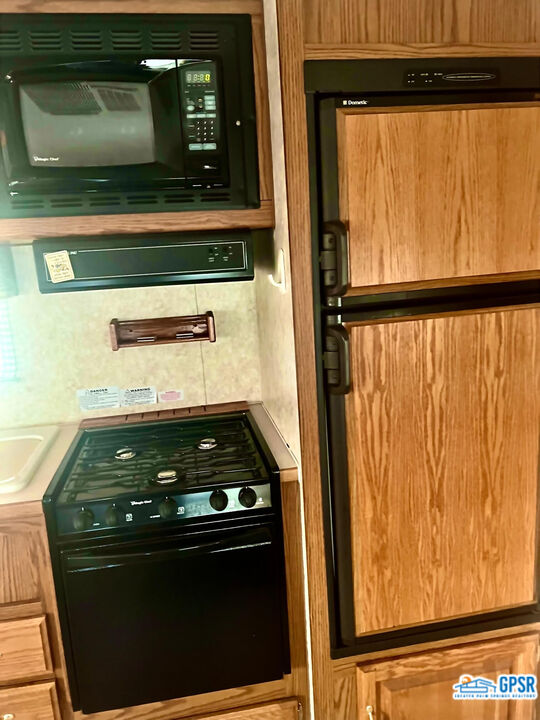 70201 Aurora Road Desert Hot Springs, CA 92241 - Photo 14 of 18 a kitchen with a stove and a microwave