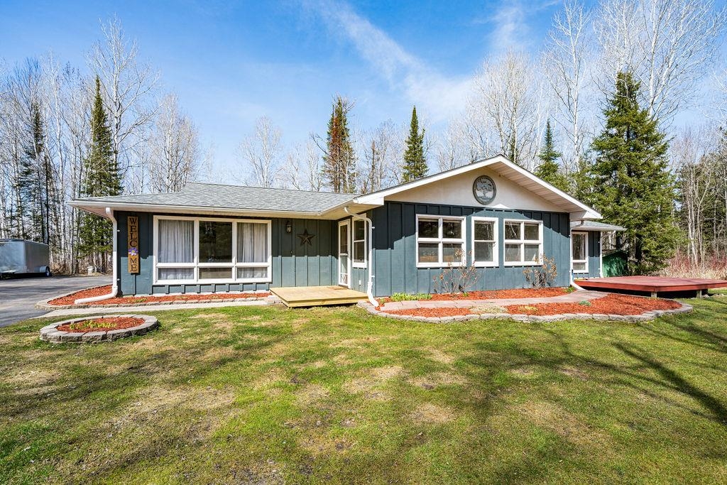 3863 Karky Road Superior, WI 54880 - Photo 1 of 33 Ranch-style house featuring board and batten siding, a wooden deck, and a front yard