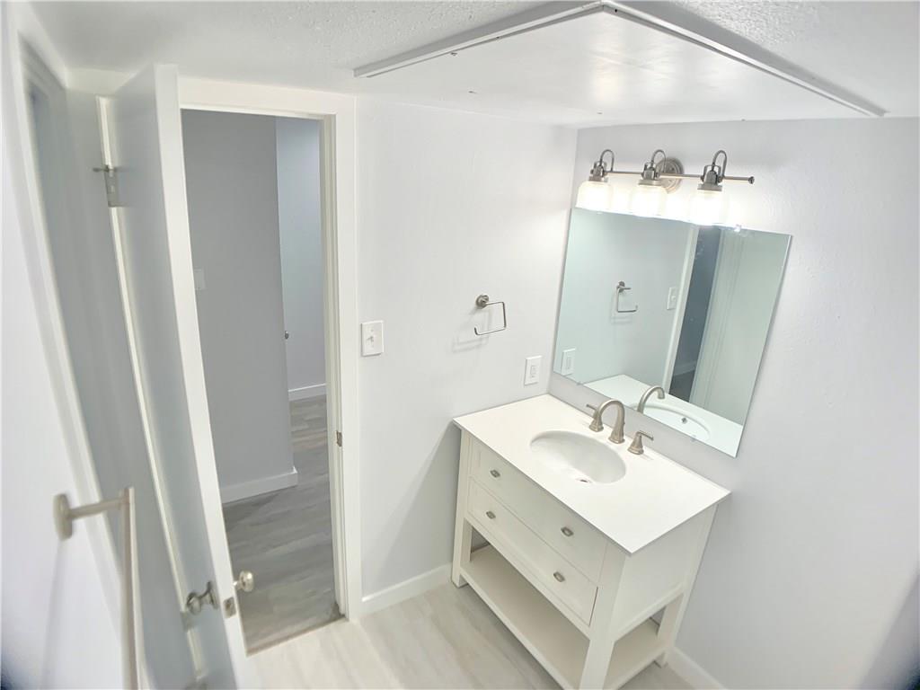 1135 Barton Hills Drive, Unit 252 Austin, TX 78704 - Photo 13 of 19 Bathroom featuring vanity, a textured ceiling, and light wood-style floors