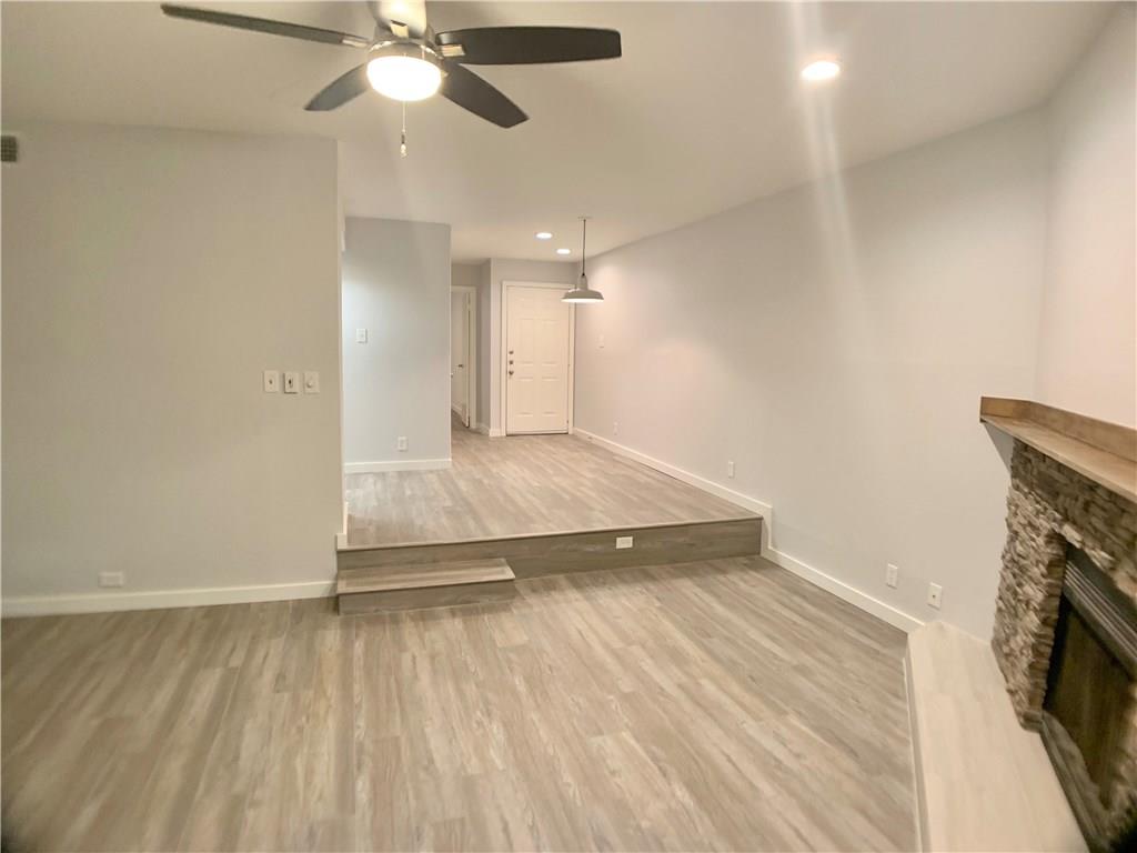 1135 Barton Hills Drive, Unit 252 Austin, TX 78704 - Photo 5 of 19 Unfurnished living room with light wood finished floors, recessed lighting, ceiling fan, and a fireplace