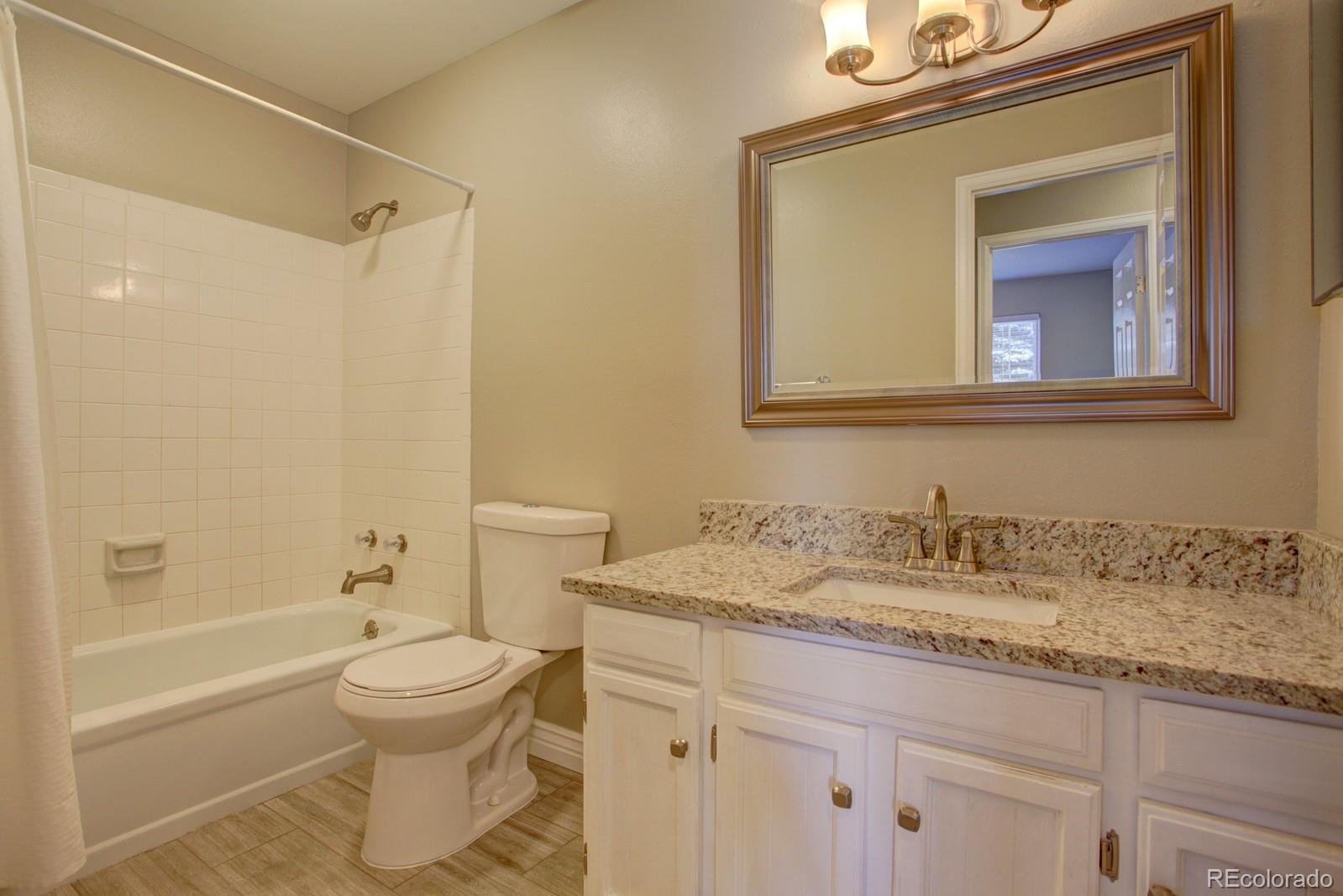 63 Prairie Ridge Road Highlands Ranch, CO 80126 - Photo 11 of 29 a bathroom with a granite countertop sink a toilet and a bathtub