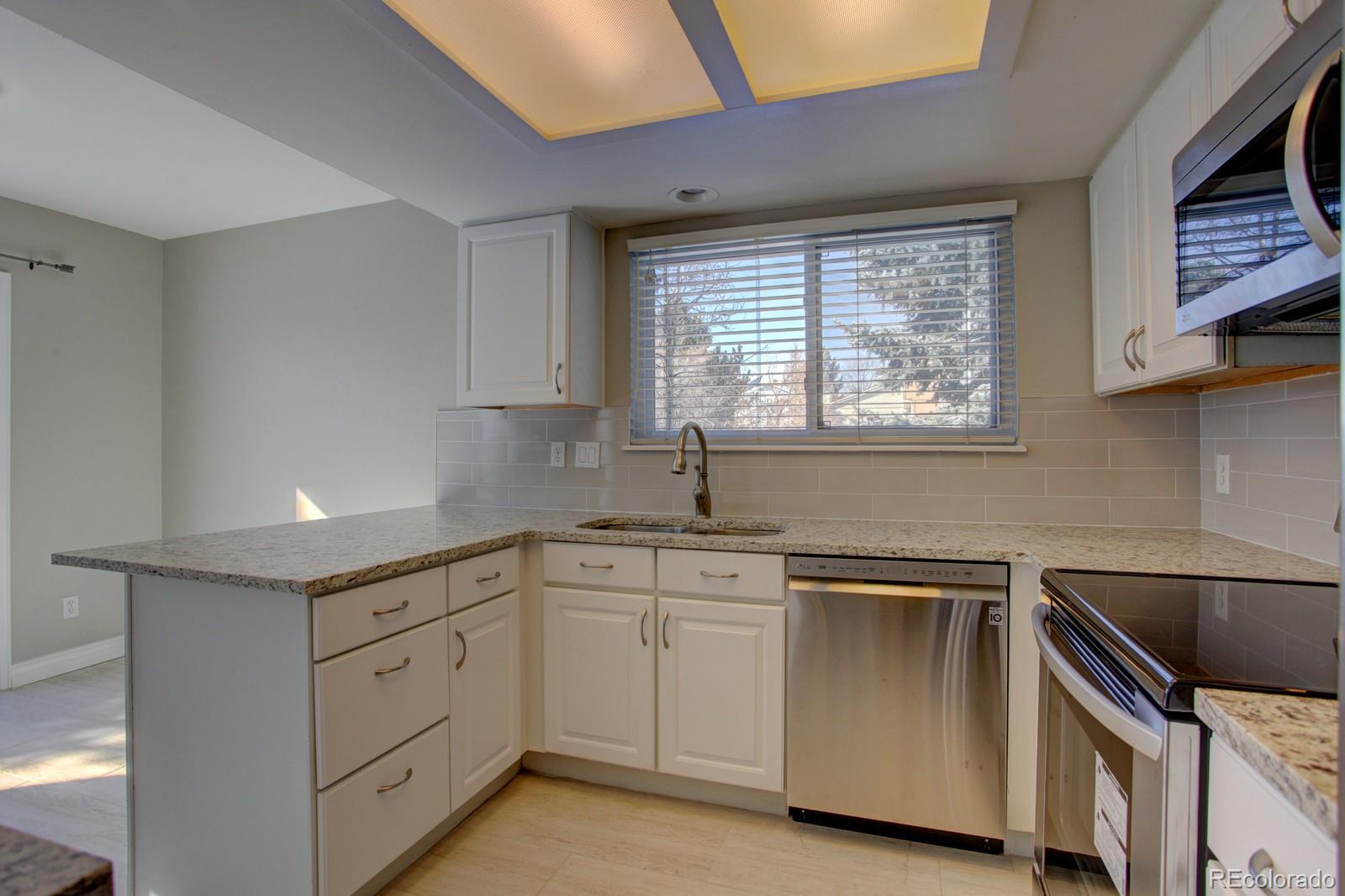 63 Prairie Ridge Road Highlands Ranch, CO 80126 - Photo 7 of 29 a kitchen with white cabinets and white appliances