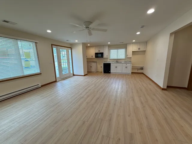 an empty room with wooden floor and windows