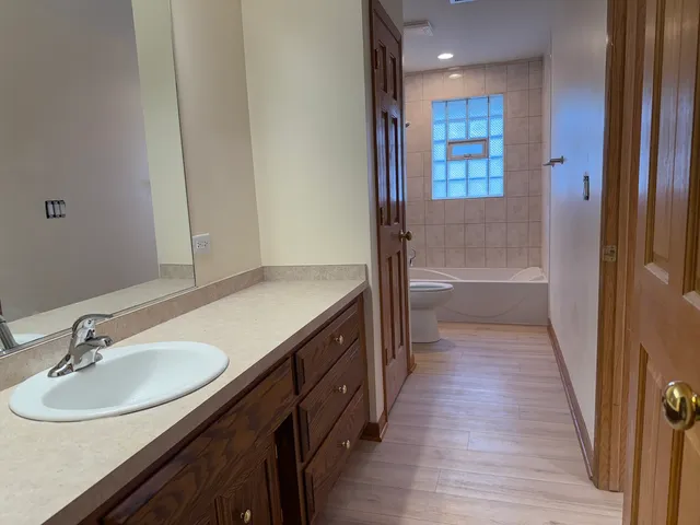 a bathroom with a sink a tub and a mirror