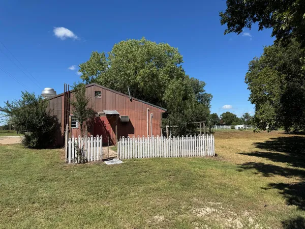 a white house that has tree in front of it