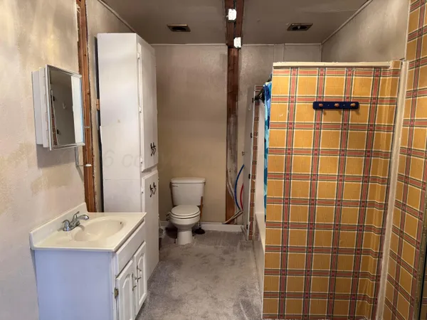 a bathroom with a sink toilet and shower