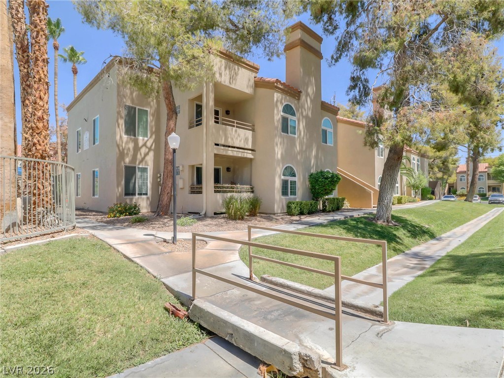 3145 East Flamingo Road, Unit 2129 Las Vegas, NV 89121 - Photo 30 of 43 A well-maintained multi-story building offers charming arched windows and inviting outdoor spaces.