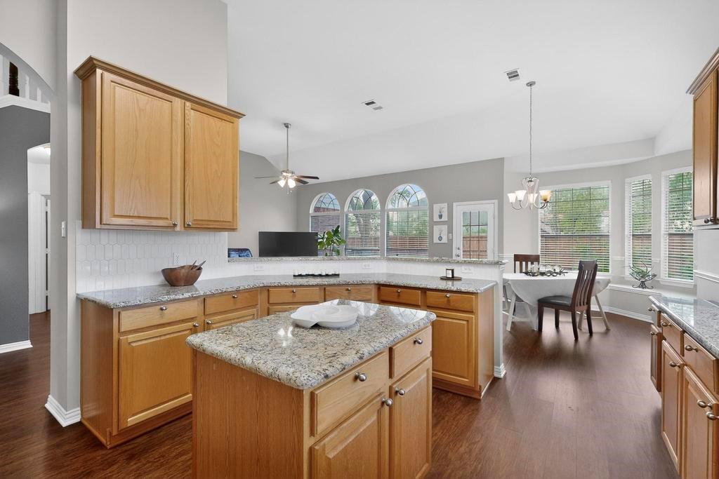 236 Hope Circle Murphy, TX 75094 - Photo 16 of 38 Kitchen with a peninsula, light stone countertops, and a center island