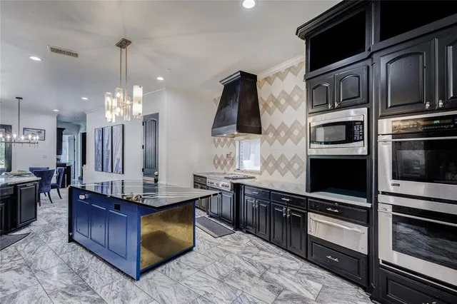 a large kitchen with stainless steel appliances granite countertop a stove and a sink