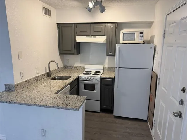 a kitchen with granite countertop a sink and a stove