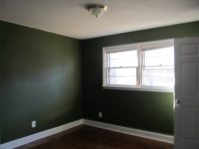 584 Oak Grove Road Goodspring, TN 38460 - Photo 7 of 12 an empty room with wooden floor and windows