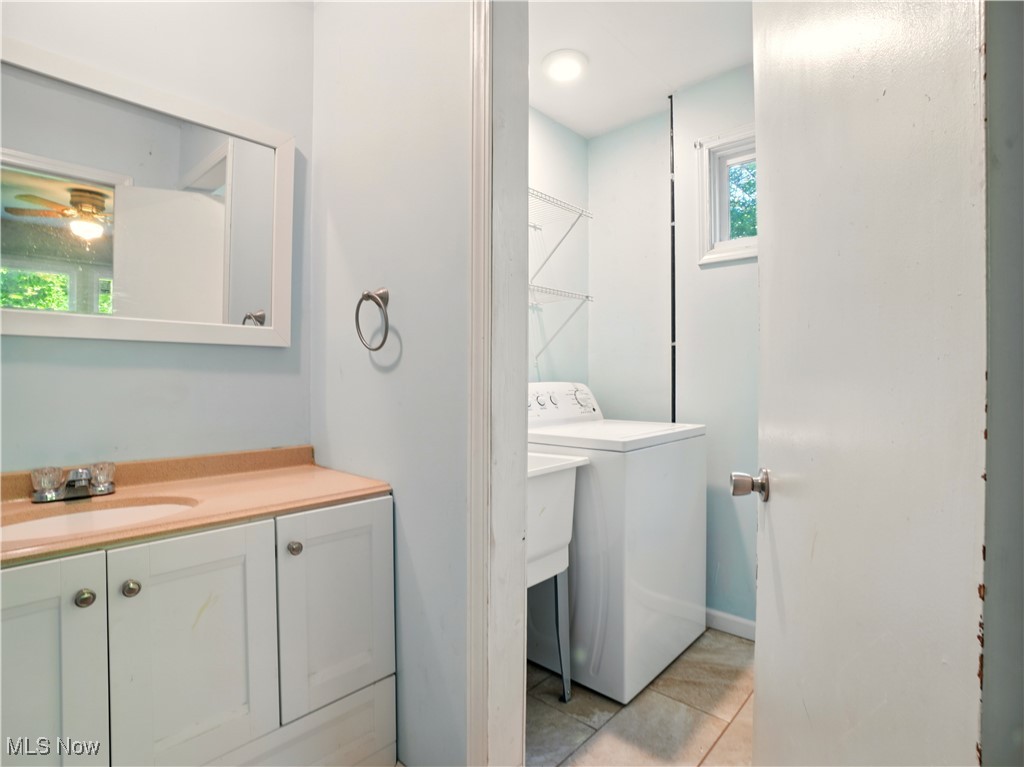 1942 Benjamin Road Madison, OH 44057 - Photo 23 of 29 Bathroom with washer / clothes dryer, tile patterned flooring, vanity, toilet, and ceiling fan