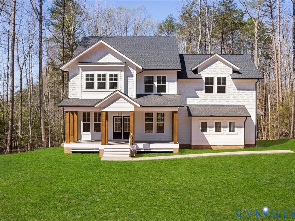 a front view of a house with a yard and trees
