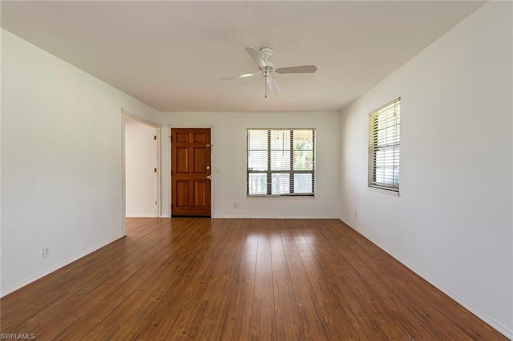 18274 Apple Road Fort Myers, FL 33967 - Photo 3 of 15 an empty room with wooden floor cabinet and windows