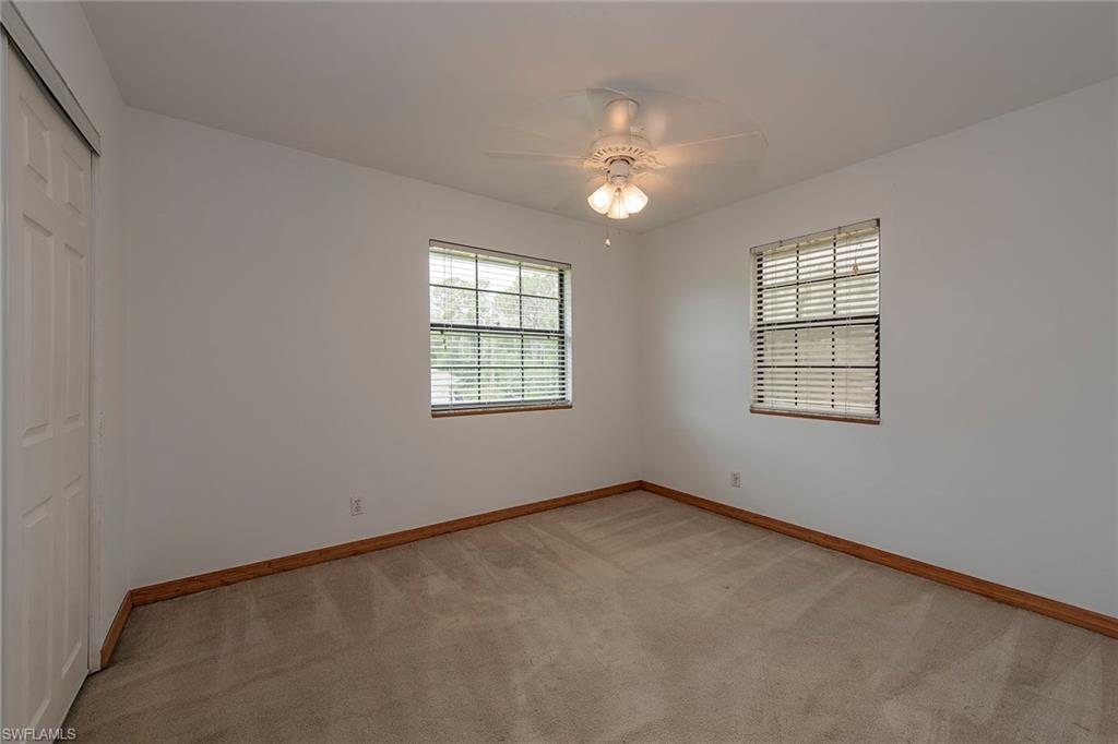 18274 Apple Road Fort Myers, FL 33967 - Photo 9 of 15 an empty room with windows and chandelier fan