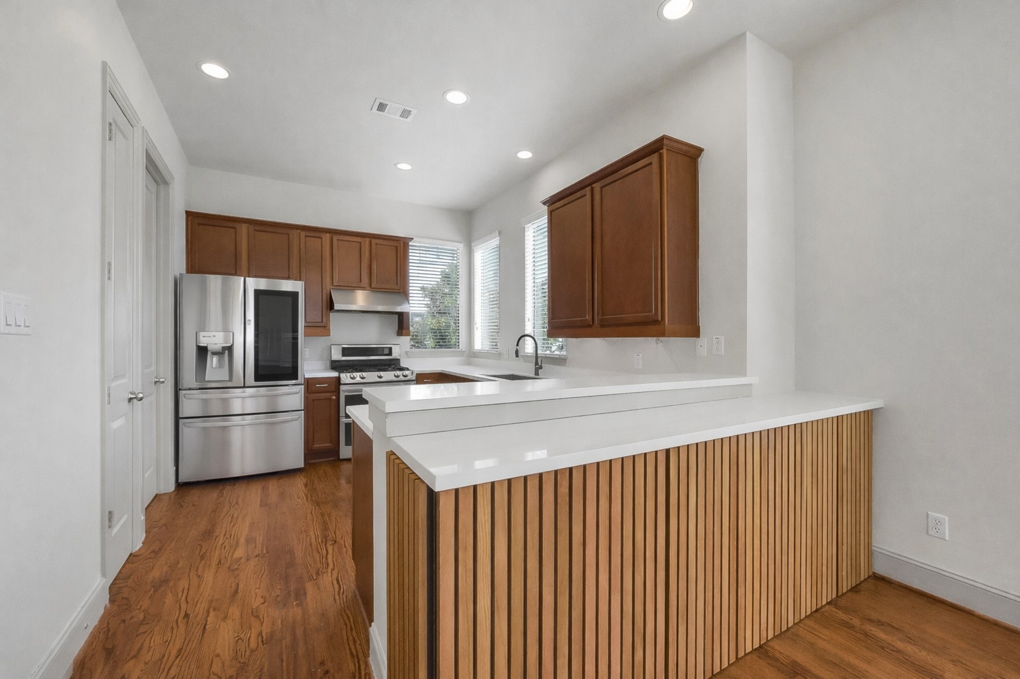 1929 Summer Street Houston, TX 77007 - Photo 11 of 27 Light and bright kitchen features quartz countertops, under-cabinet lighting, recessed can lighting, and ample storage. Notice the added built-in storage at the breakfast bar area.