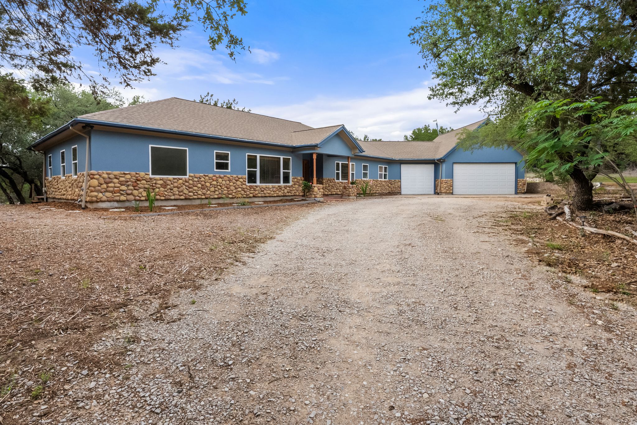 200 Vista West Ranch Road Dripping Springs, TX 78620 - Photo 2 of 20 Ranch-style exterior with a blue facade and a natural stone base