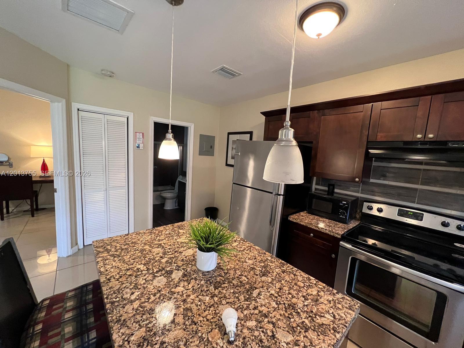 2015 Funston Street, Unit 2 Hollywood, FL 33020 - Photo 3 of 19 a kitchen with a stove and a wooden floor